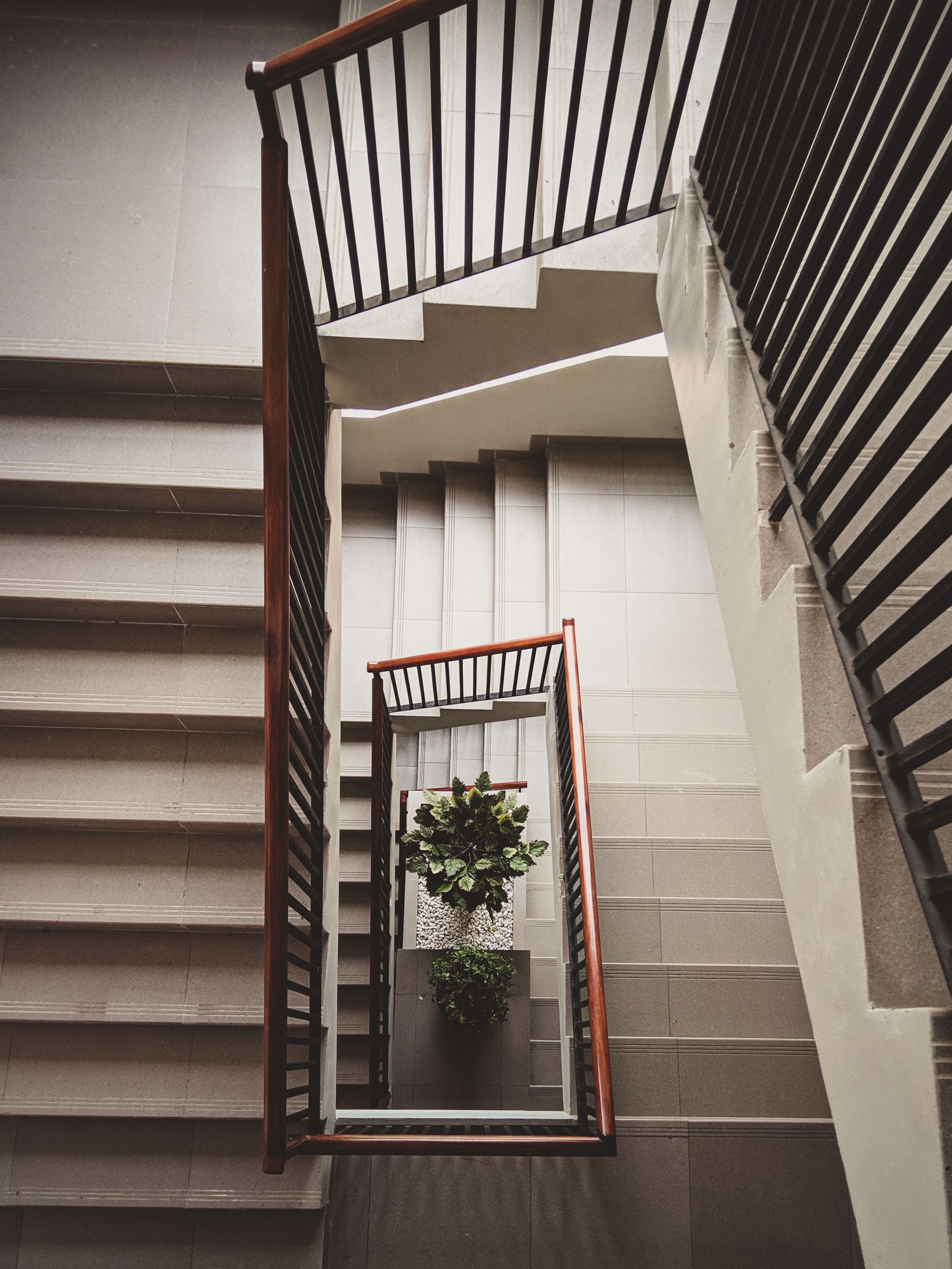 Trap met donkere metalen balustrades en lichte wanden.