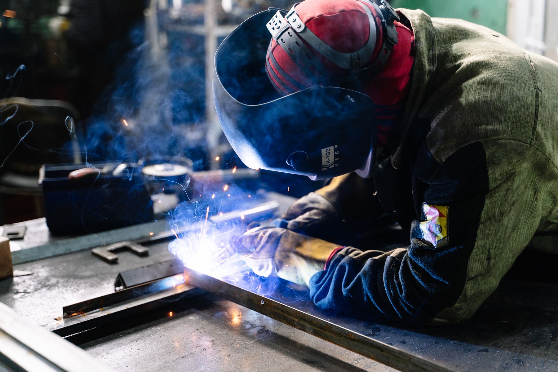 Lasser verbindt metalen profielen op een werkbank.