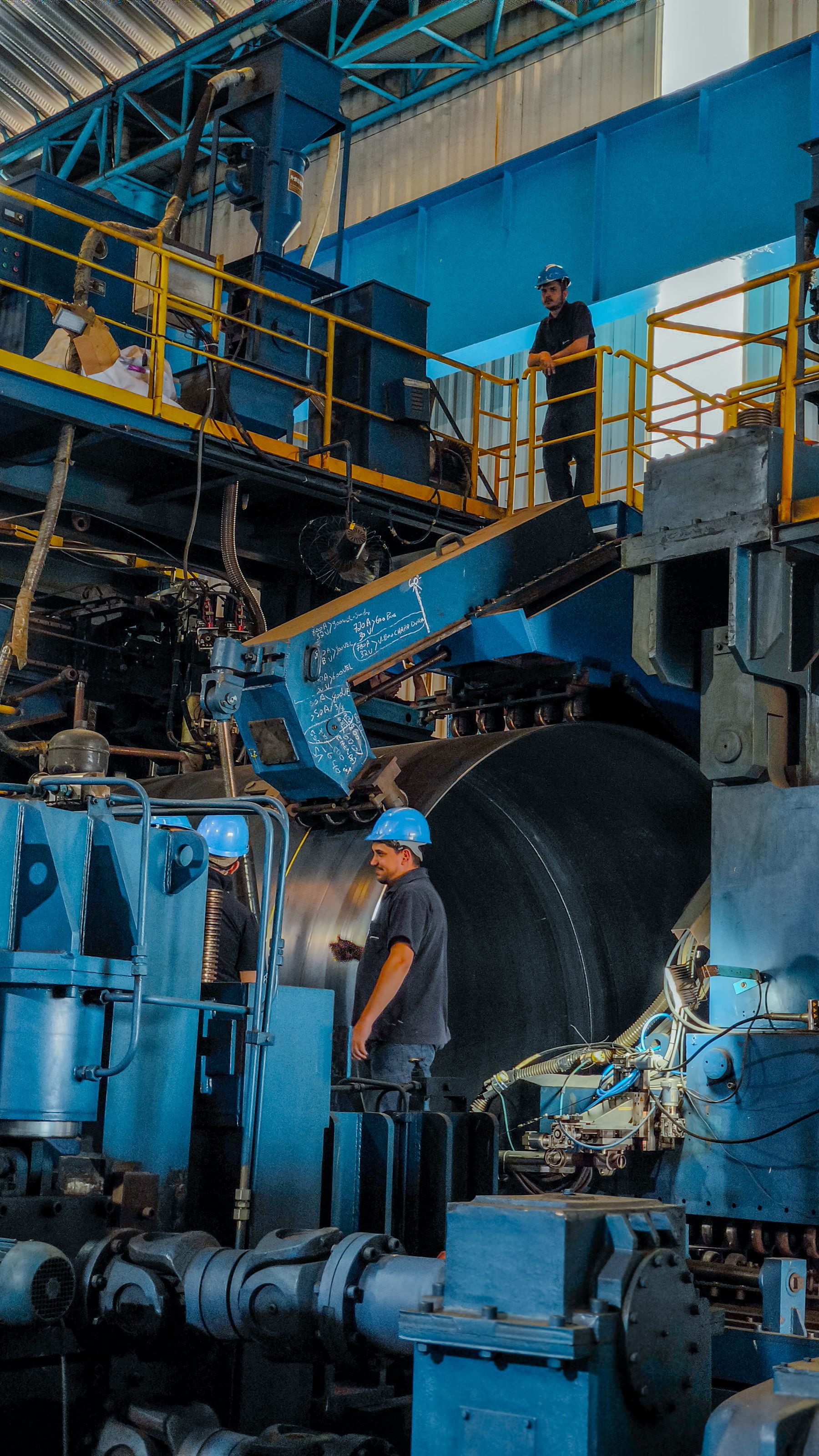 Medewerkers en machines in een grote metaalfabriek